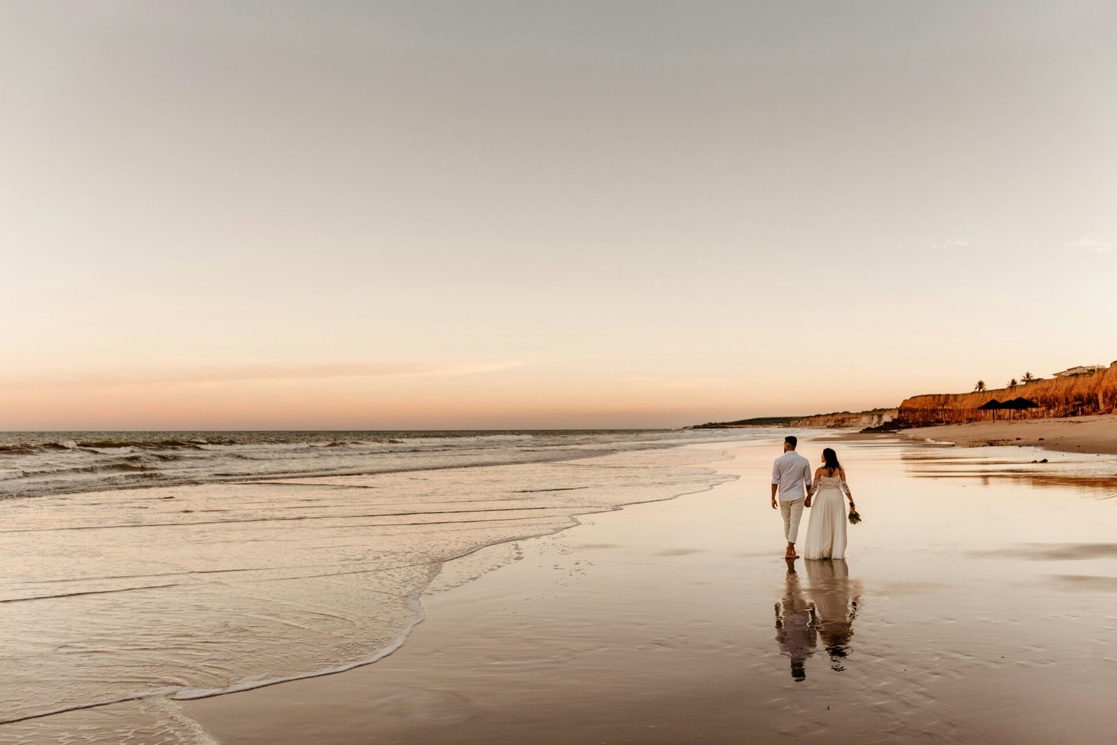 A just married couple walking down the beach