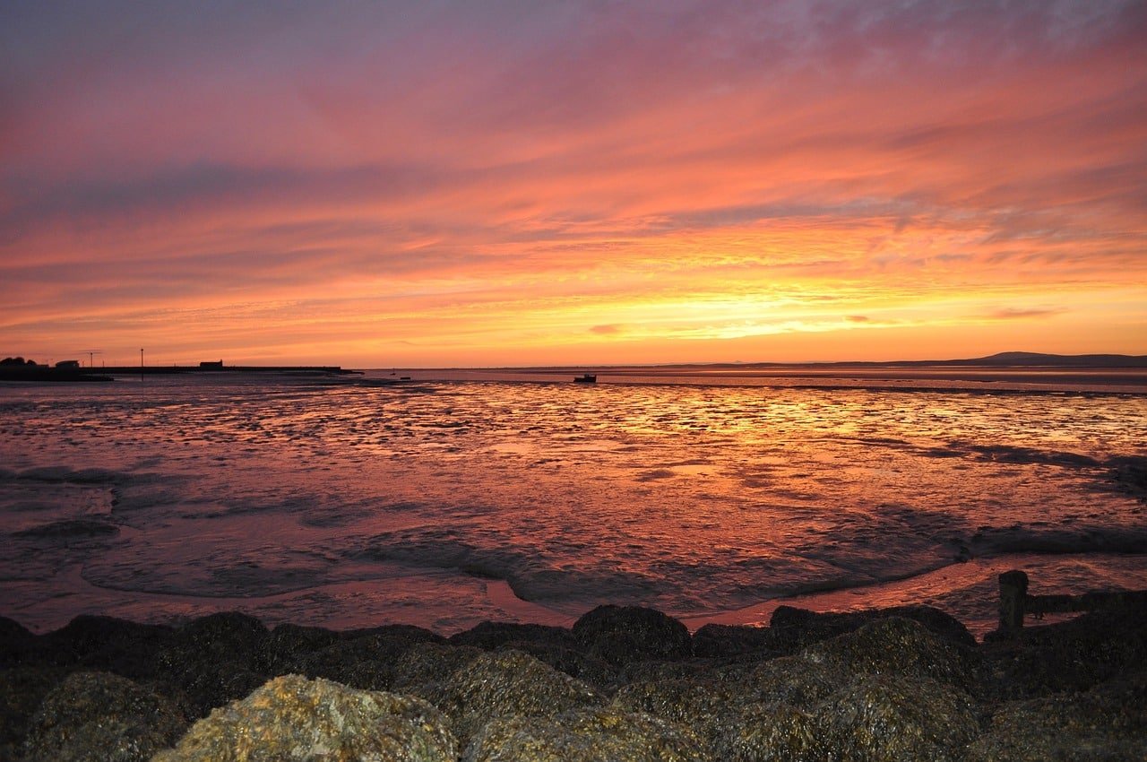 Vibrant sunset over the ocean with rocky shore